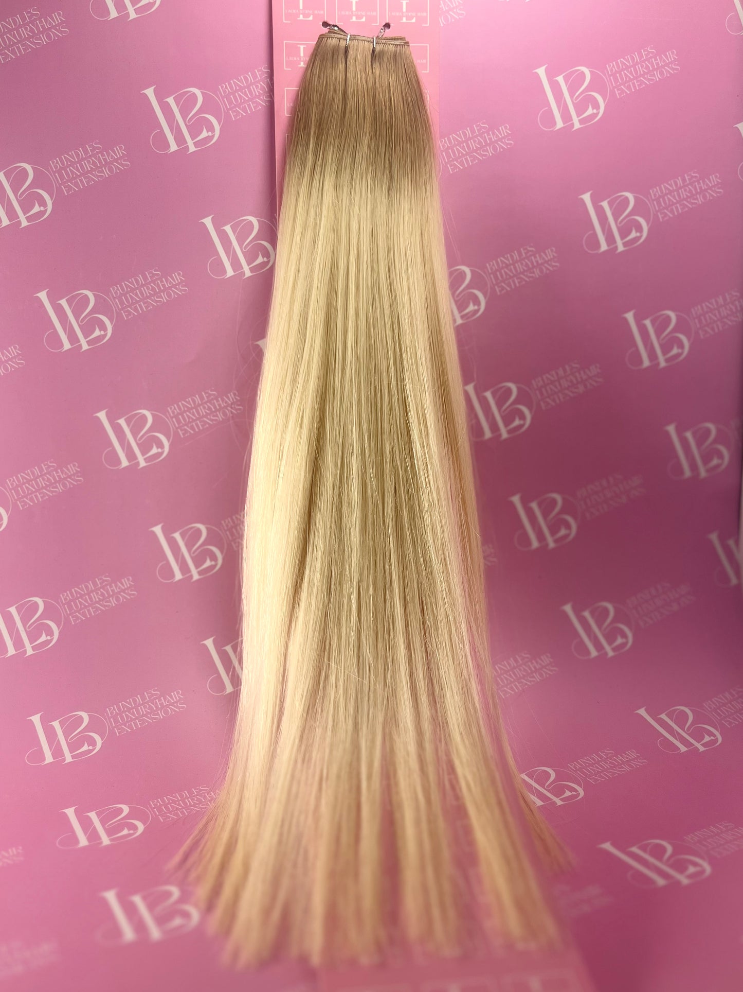 Blonde hair extensions on a pink background with 'IB' branding.