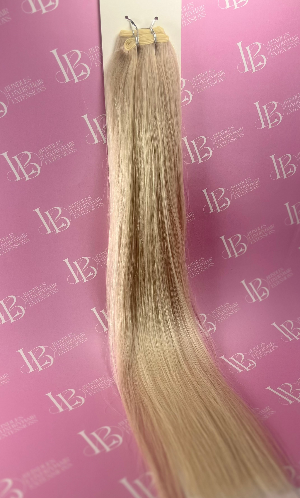 Blonde hair extensions on a pink background with 'IB' branding.